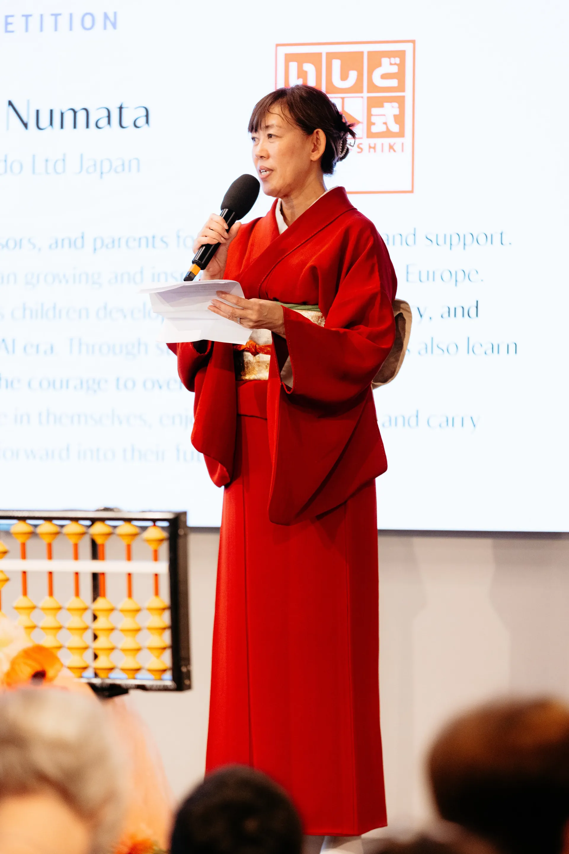 海外大会で挨拶する沼田代表